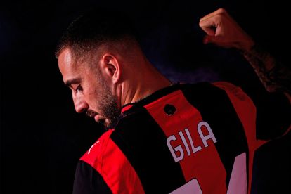 Mario Gila smiling while presenting his official AC Milan jersey during a club event